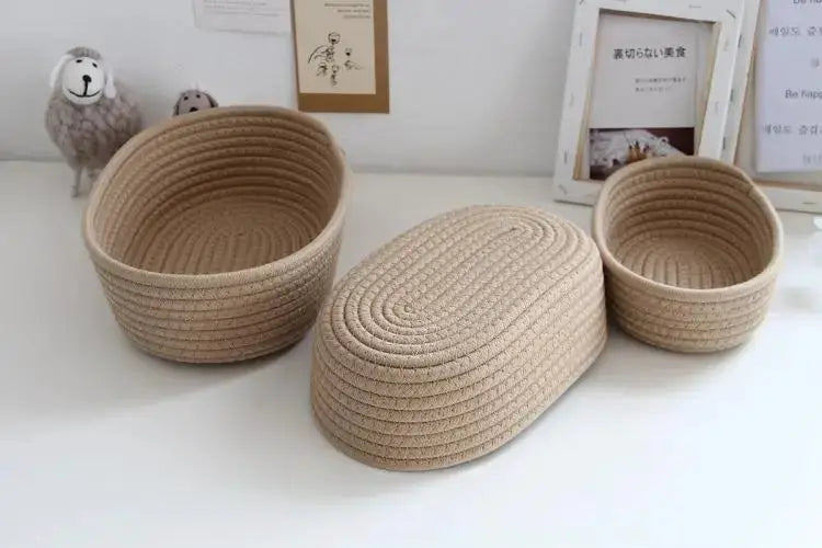Set of three natural beige woven storage baskets for desk organization; large, medium with lid, and small.