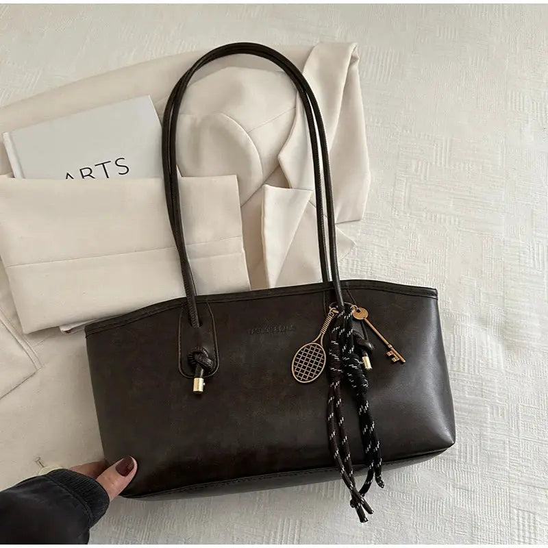 European American retro tote bag by Simples Market in dark brown leather with pendant charms.