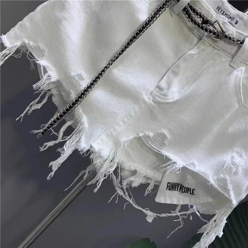 White raw-edge denim mini skirt with frayed hem and distressed holes, exposed pockets.