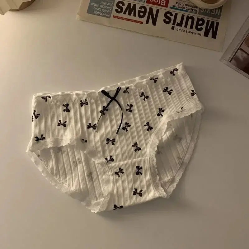 Women's white cotton seamless panties with ribbed texture, lace trim, and small black bow accents (mid-rise)