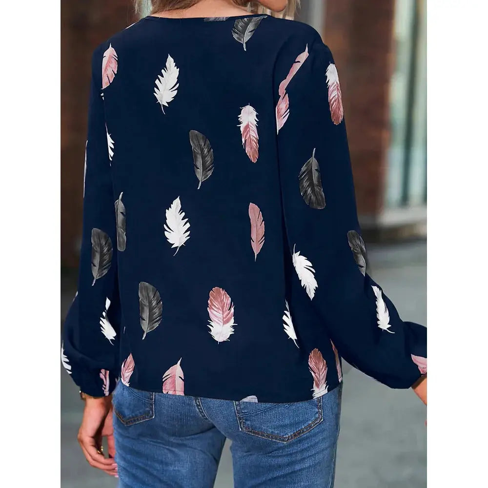 Women's navy chiffon blouse with pink, white, and gray feather print, long sleeves.