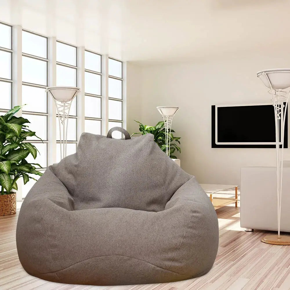 Bean bag chair cover, large gray fabric, in a modern living room with plants.