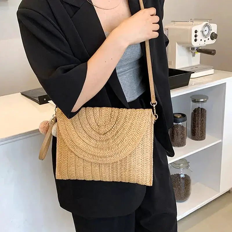 Handmade straw crossbody bag with envelope woven pattern, tan color, pom-pom charm