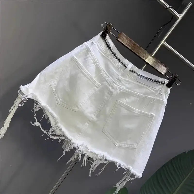 White denim mini skirt with frayed hem, two back pockets, and waist chain detail.