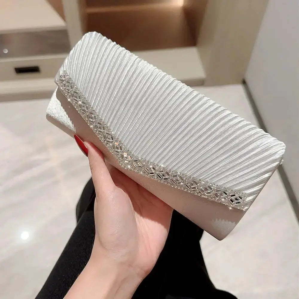 Women's evening clutch bag in silver/white with pleated texture and crystal-embellished edge