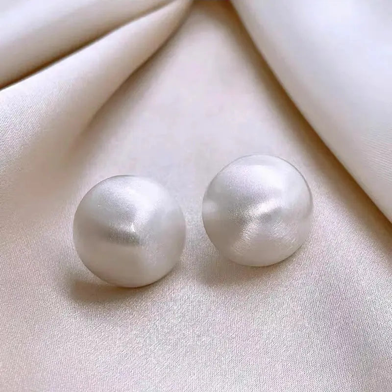 White frosted sphere stud earrings by Simples Market, pair.