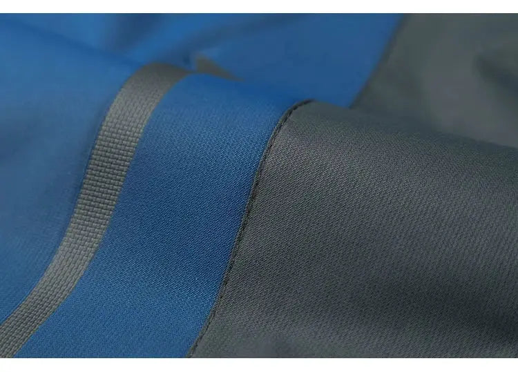 TRVLWEGO waterproof hiking jacket close-up of blue and black fabric with gray seam