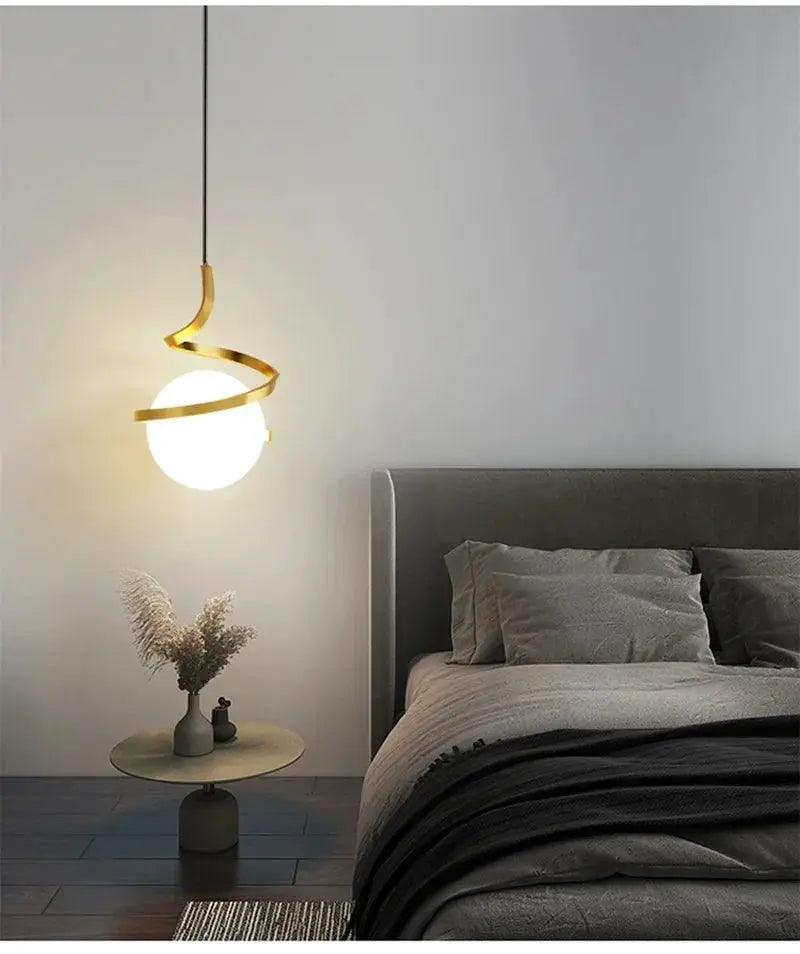 Nordic LED pendant light with white globe and gold spiral accents, suspended above a bedside in a gray bedroom