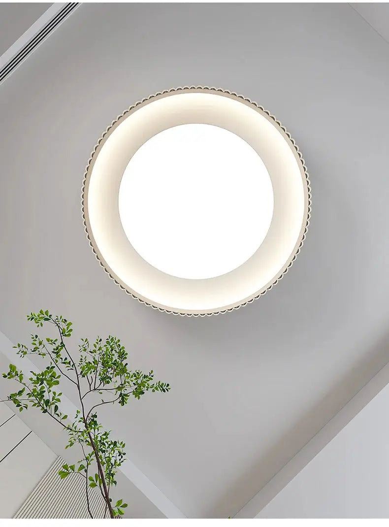Modern round metal LED ceiling light with a white diffuser and glowing outer ring.