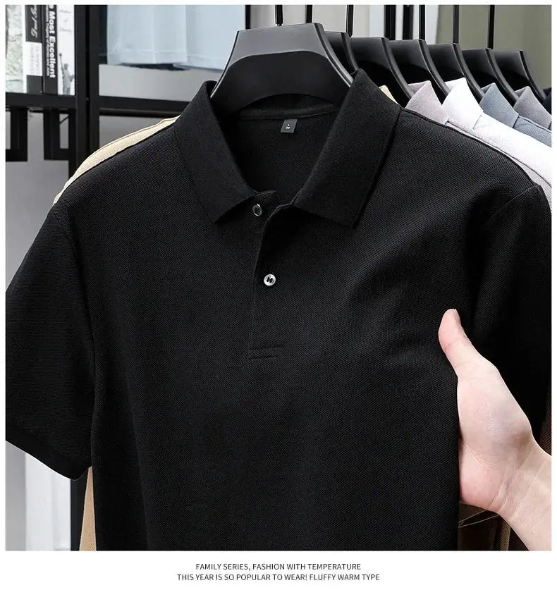 Men's black 100% cotton polo on a hanger; five polo shirts in assorted colors visible in background