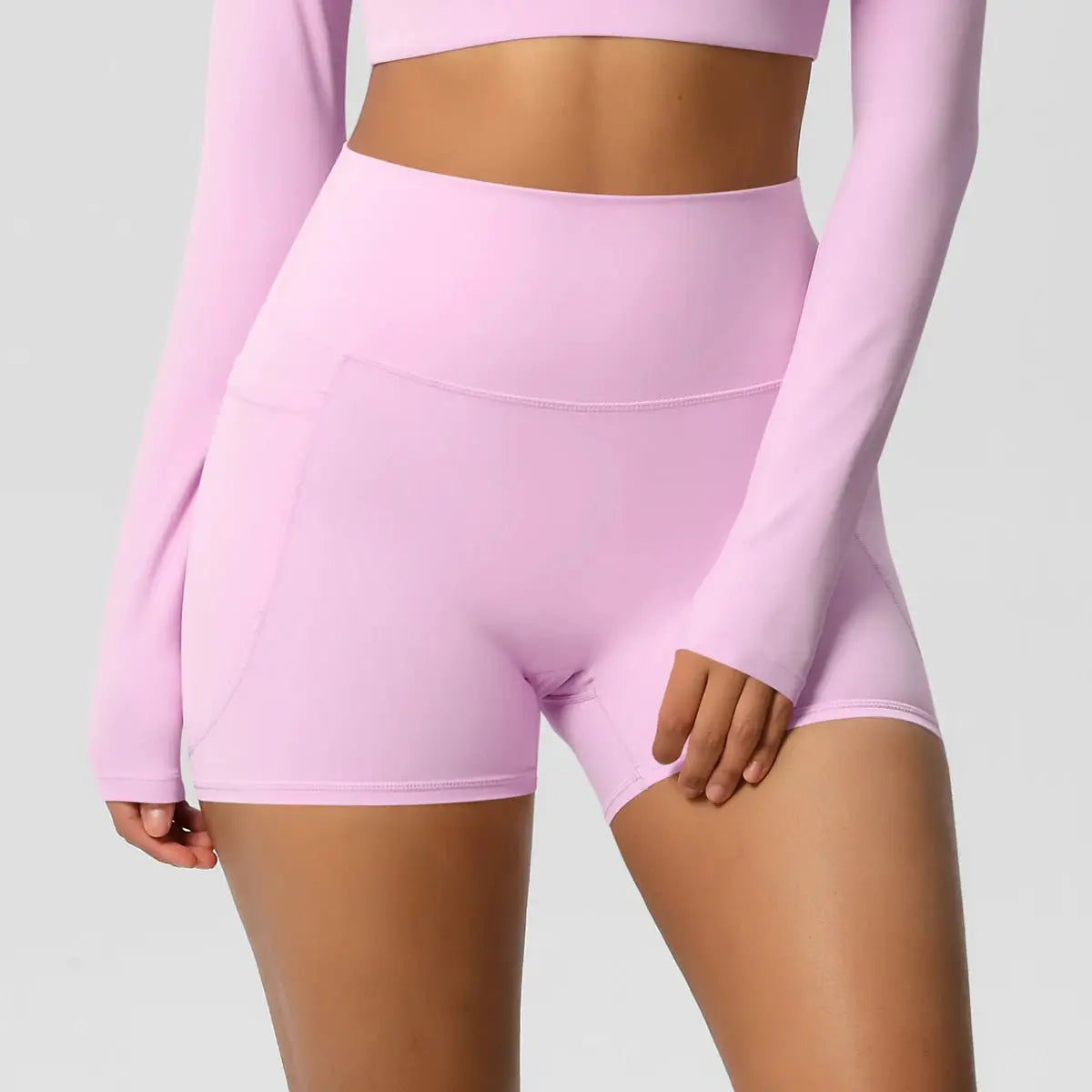 Women’s pink pocketed yoga shorts, high-waisted and quick-dry athletic wear.