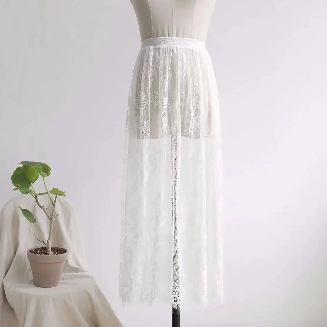 White lace long skirt with sheer tulle overlay and elastic high waist on a dress form