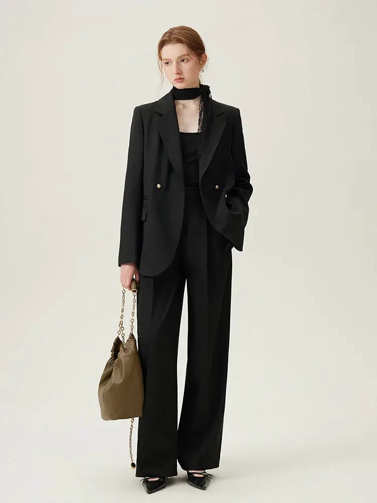 Simples Market FSLE black blazer suit with wide-leg pants and brown chain-strap handbag.