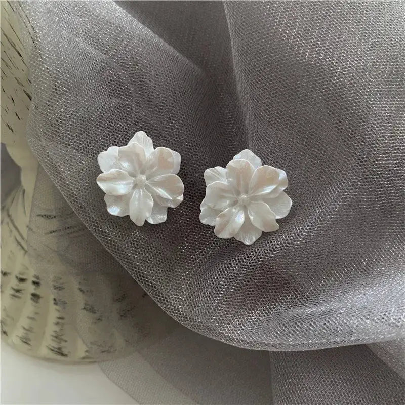 White flower stud earrings for women, camellia-style pair with pearl-like petals.