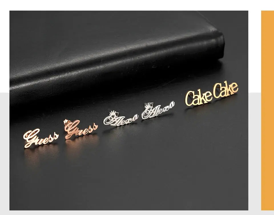 Logo script stud earrings set in rose gold, silver, and gold tones; several pieces featuring Guess and Cake Cake logos