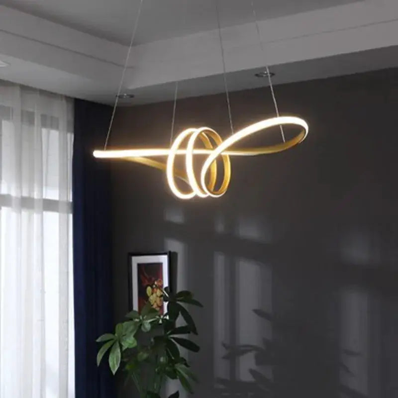 Modern kitchen island pendant light with intertwined gold LED rings and remote dimming.