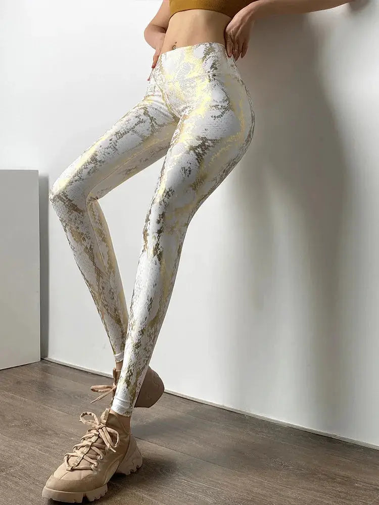 Snake printed yoga pants for women by Simples Market; high-waist, white and gold snakeskin pattern leggings.