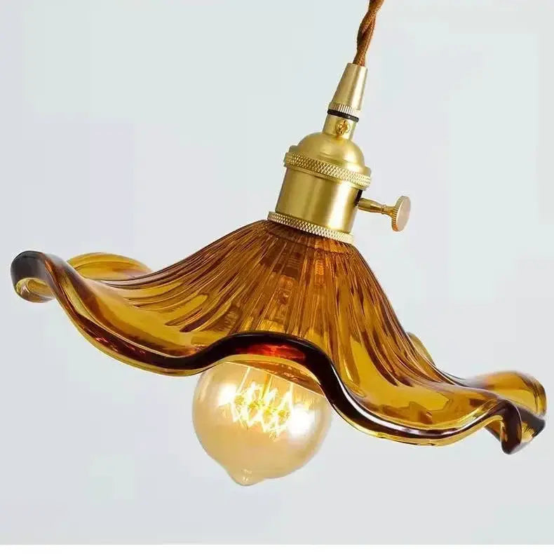 Amber glass pendant light with a flowing wave shade and brass hardware LED bulb