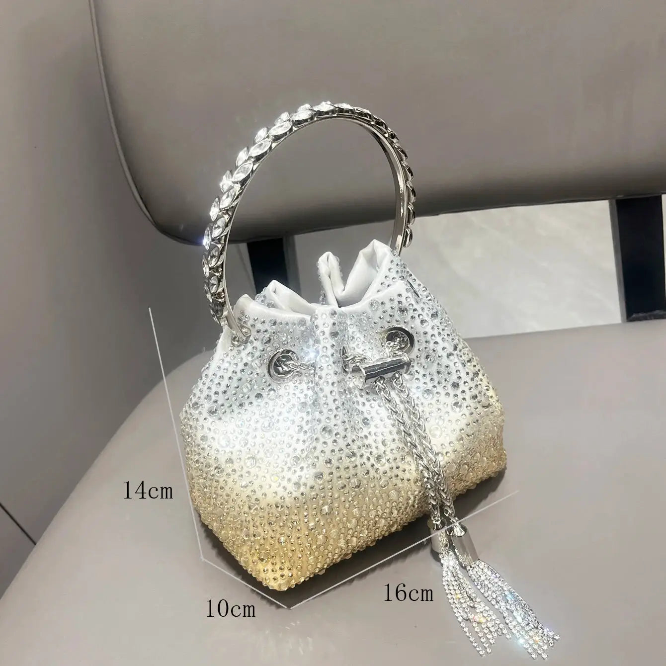 Rhinestone evening clutch bag with circular crystal handle and silver-white gradient body with crystal tassel