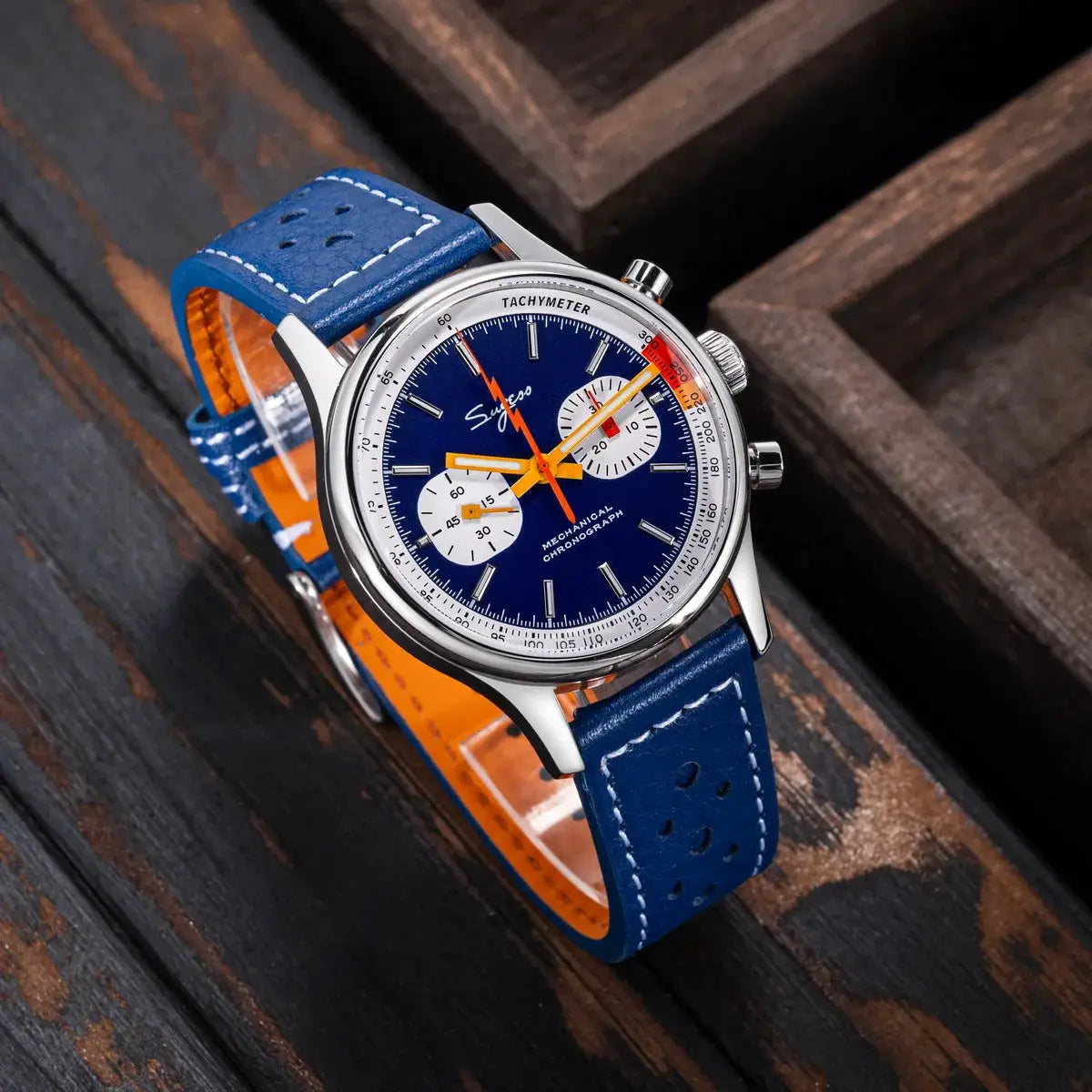 Sugess chronograph watch for men with blue dial, orange hands, white subdials, tachymeter bezel, and blue leather strap.