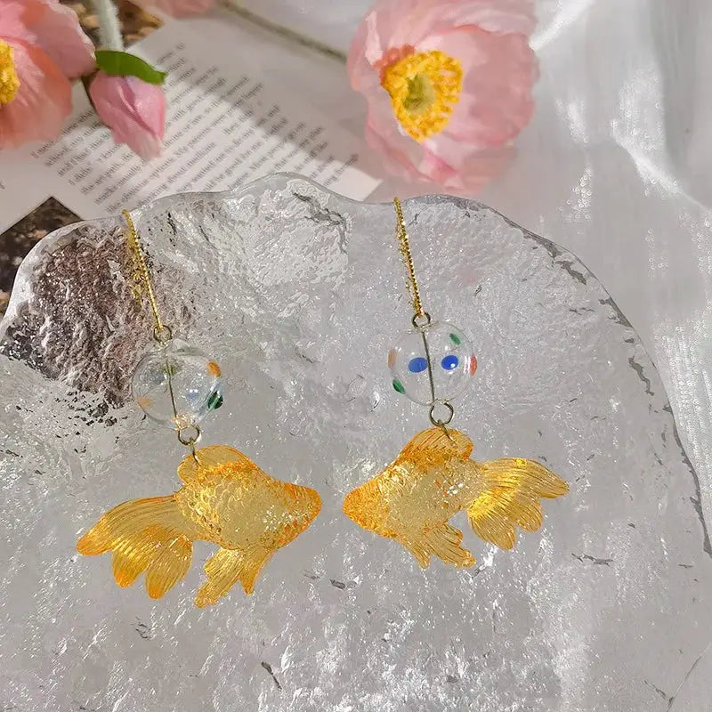 Pair of goldfish drop earrings with transparent multicolor-dotted bead and gold-tone fish charms
