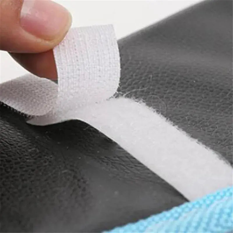 Toilet seat cover plush mat with white Velcro strap on black surface; waterproof fabric.