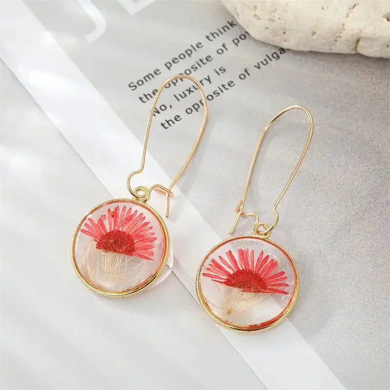 Pair of natural flower dangle earrings with red pressed flower encased in clear epoxy resin on gold-tone hoops