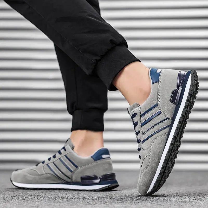 Pair of gray artificial leather men's casual sneakers with blue accents