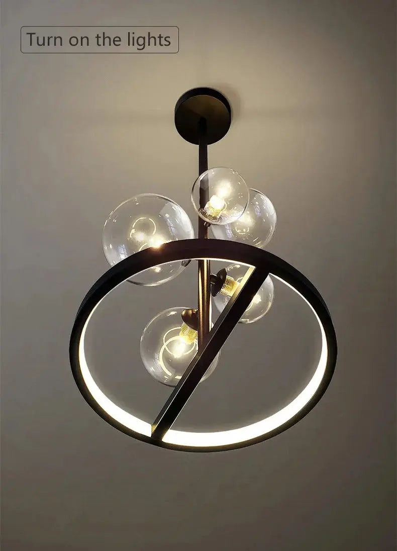 Modern art glass chandelier by Simples Market; black metal frame with circular LED ring and clear glass globes