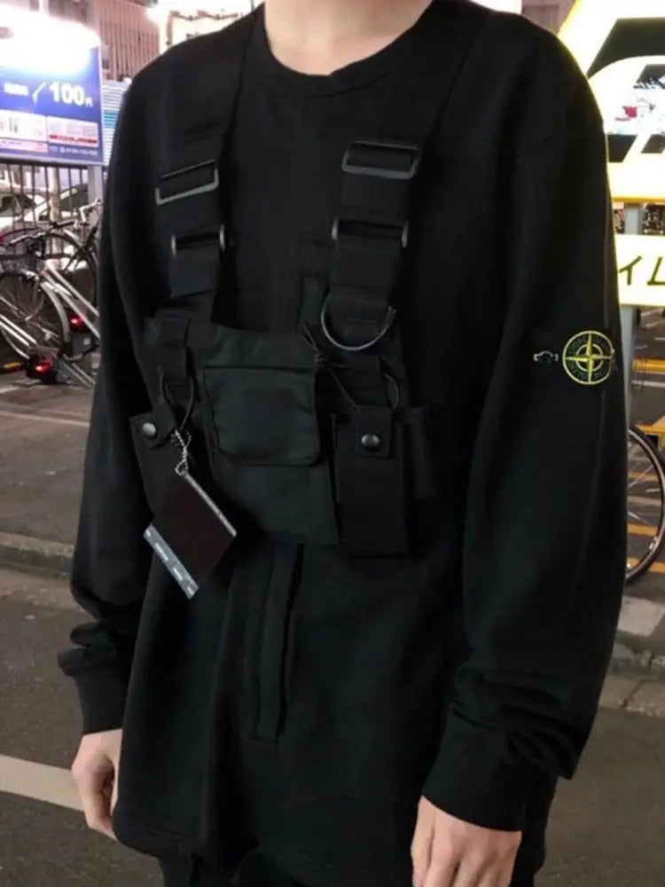 Black tactical chest rig bag with multiple pockets and adjustable straps worn over a black top.