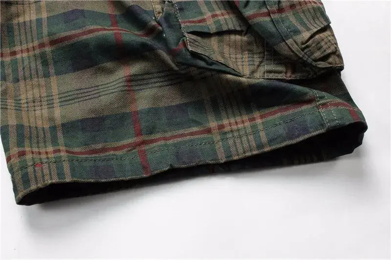 Men's plaid shorts close-up in green and brown tones with red accents.