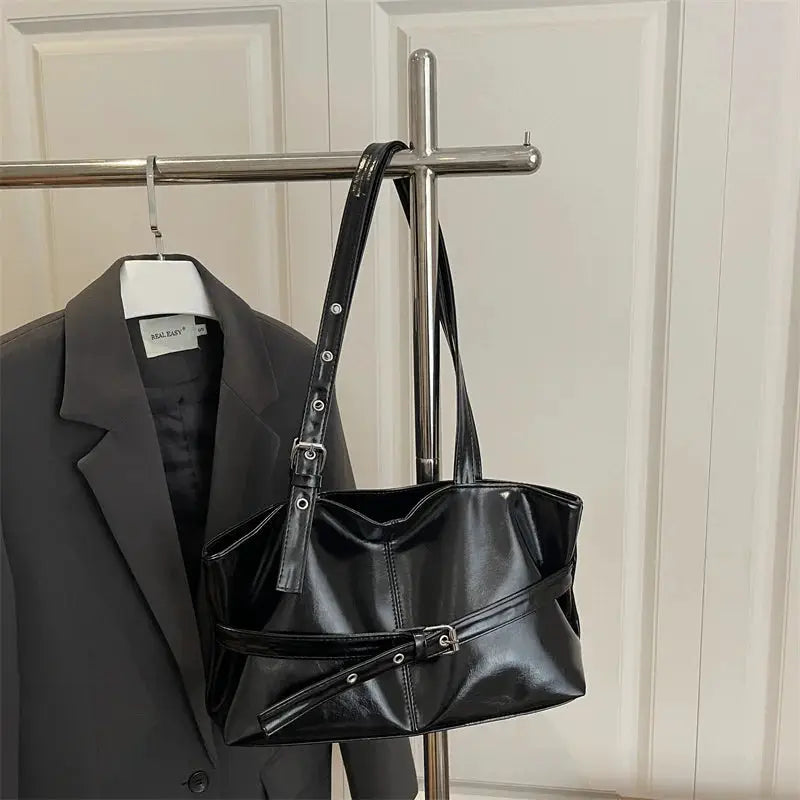 Black soft leather handbag with belt-buckle strap and adjustable shoulder bag by Simples Market