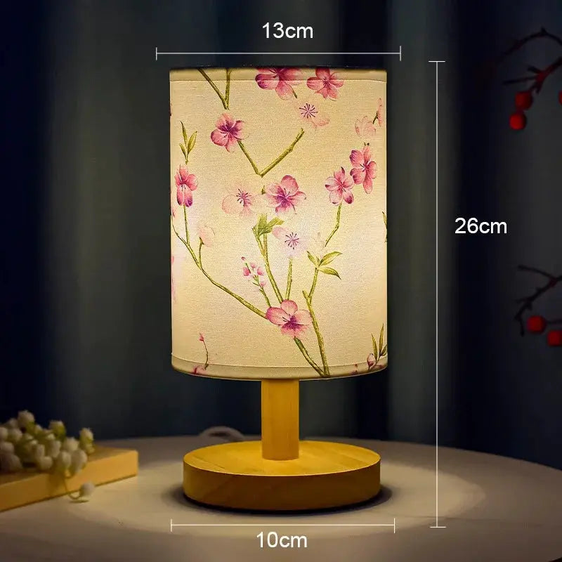 LED table lamp with fabric plum blossom shade on a round wooden base, dimmable bedside light.