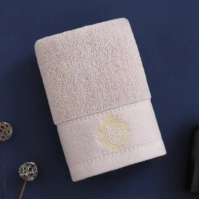 White cotton towel set, rolled with embroidered crest on the hem