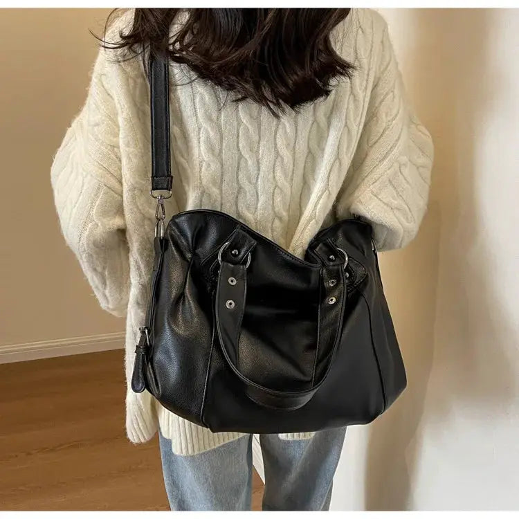 Soft interior compartment shoulder bag in black PU leather with dual top handles and long crossbody strap