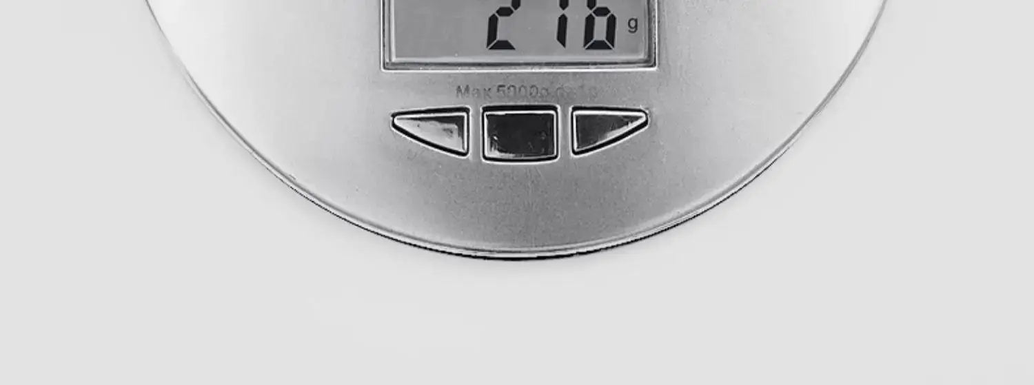 Round silver digital kitchen scale with display showing 216 g and three control buttons