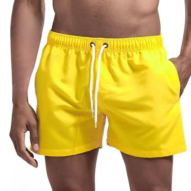 Men's yellow swim shorts with white drawstring and side pockets; quick-dry breathable fabric