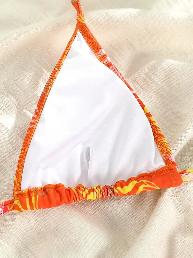 Triangle bikini top with orange printed trim and white lining; string ties