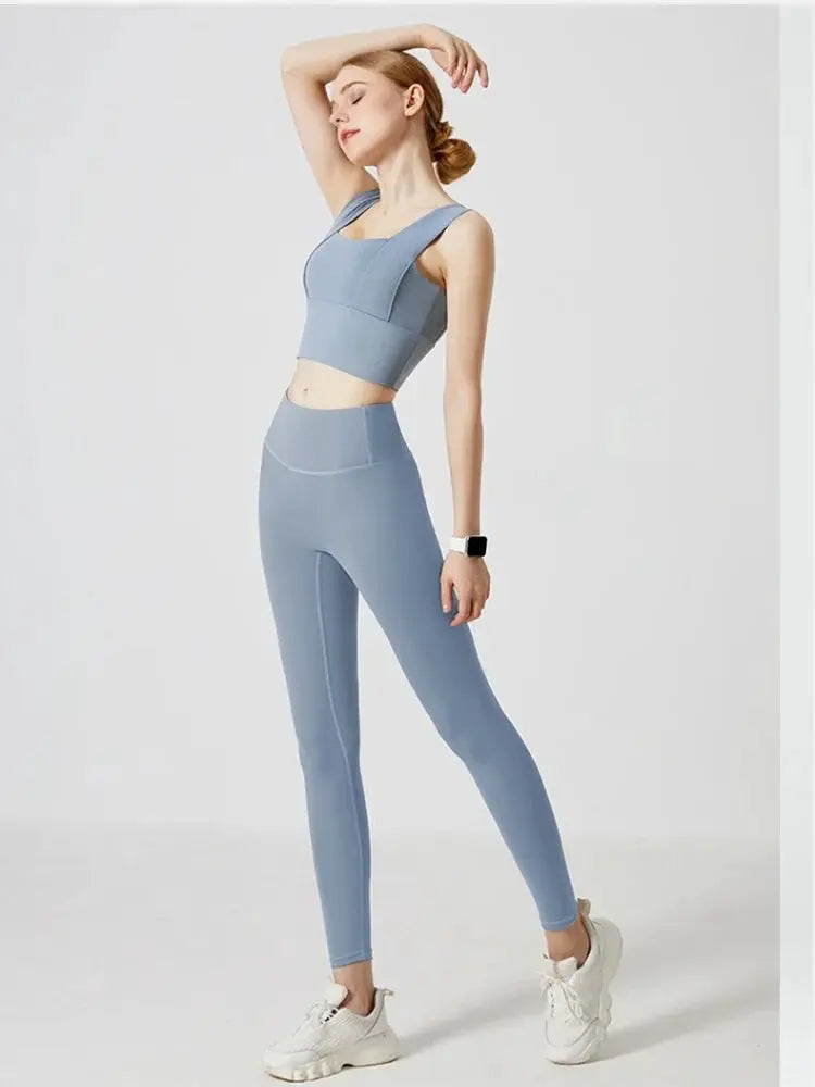 Blue high-waist women's yoga leggings with matching sports bra on model