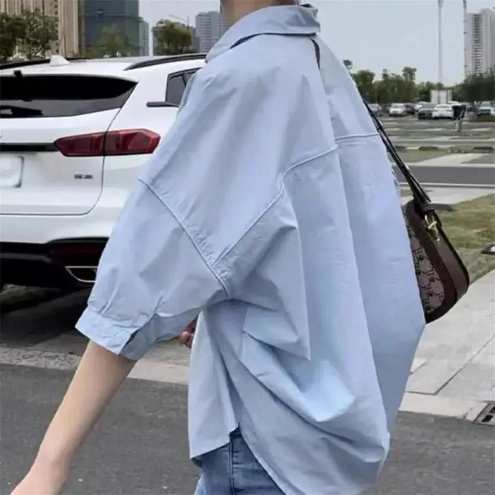 Summer shirt for women in light blue, oversized blouse with mid-length sleeves and casual loose fit.