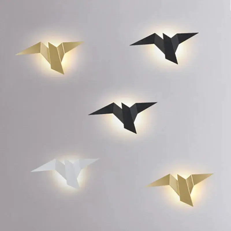 LED bird wall lamps set (5) in gold, white and black with warm backlit origami-style fixtures.