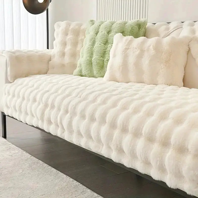 Simples Market thick rabbit fur plush sofa slipcover in ivory; non-slip, on a modern sofa with tufted cushions.