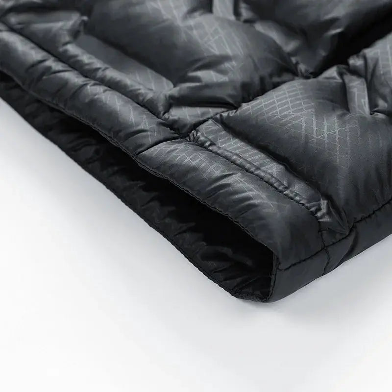 Men's black quilted down jacket close-up showing padded sleeve cuff and stitching