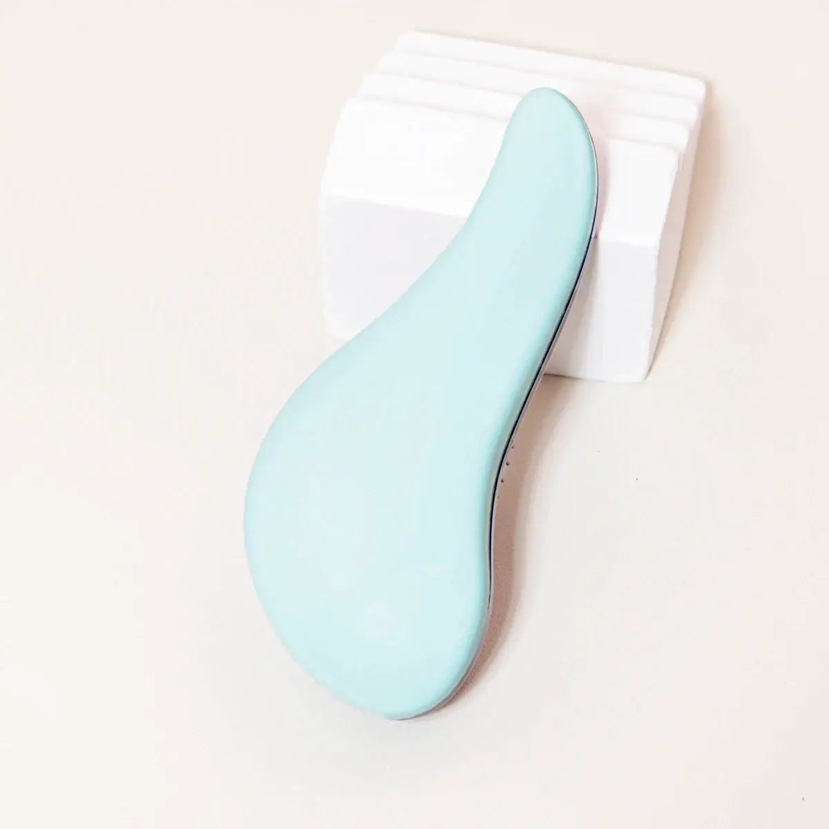 Antistatic massage brush with light blue curved handle for wet hair and wigs