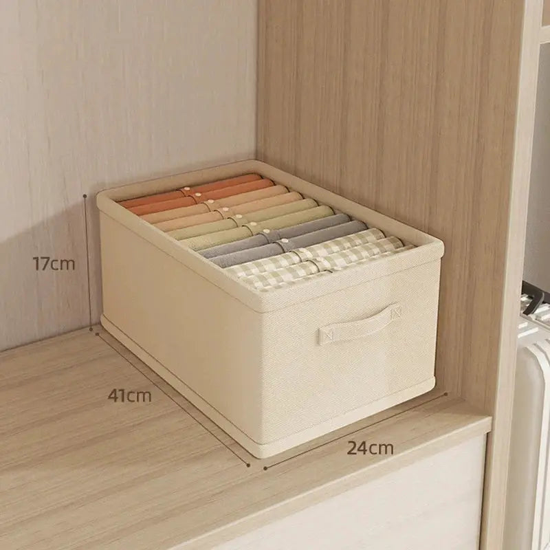 Clothes organizer storage box in beige fabric with a handle, filled with rolled garments for wardrobe storage — Simples Market