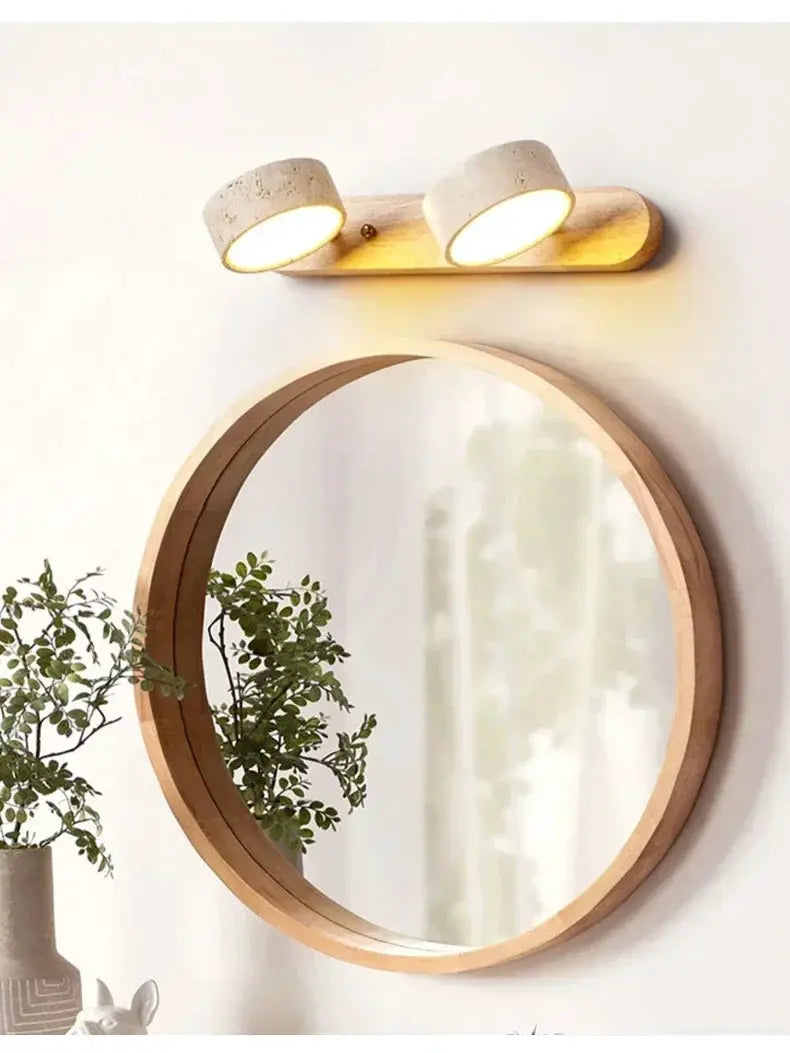 Round wooden-framed mirror with dual LED wall lights featuring concrete-style heads on a wooden base by Simples Market