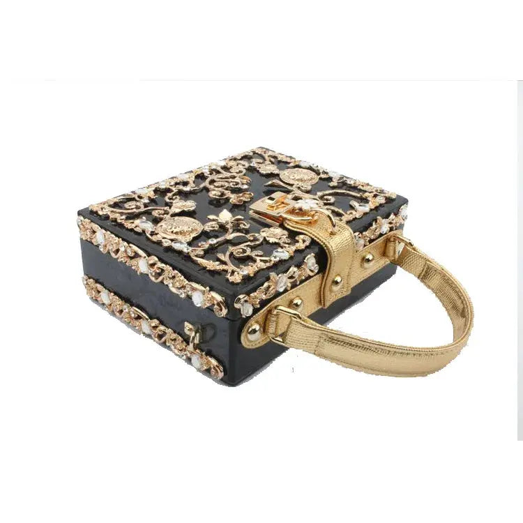 Crystal evening bag with black box, gold-tone hollow-out floral embellishments, and a gold handle.