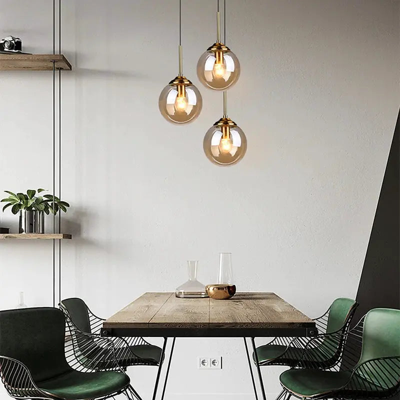 Modern luxury glass pendant chandelier; gold-tone brass with clear glass globes and warm LEDs over dining table