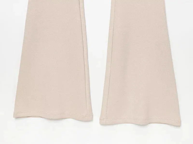 Long beige jumpsuit pant legs with flared hems and clean seams