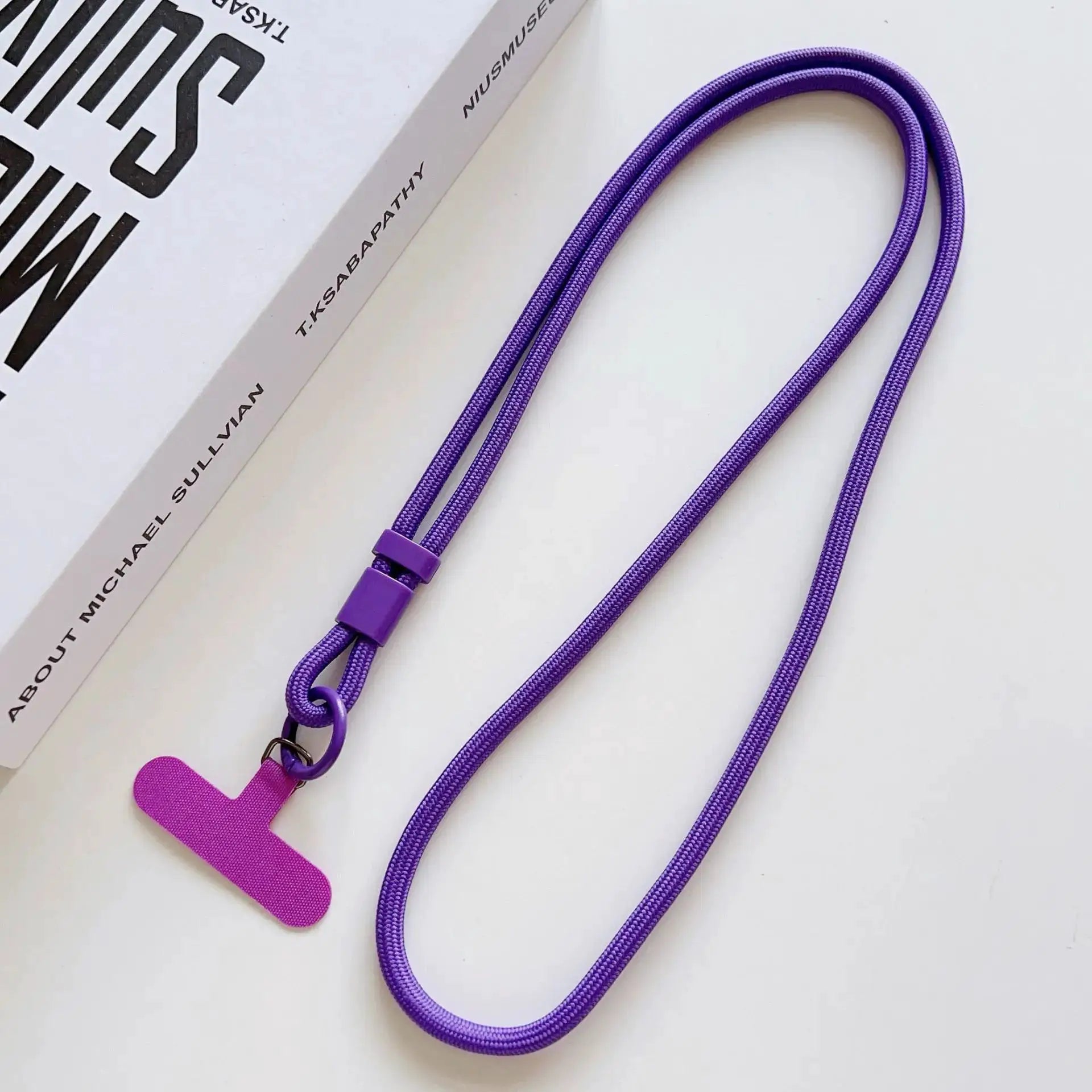 Mobile phone lanyard in purple with pink end tag and metal clip; Simples Market box visible.